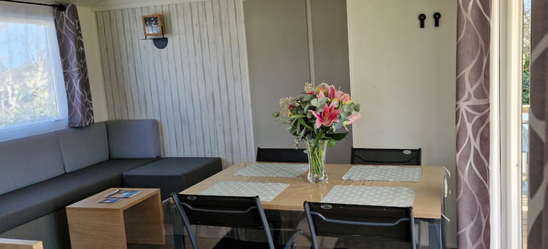 Salon et salle à manger du mobil-home Bahia 2025, en location au camping La Petite Ville en Bretagne