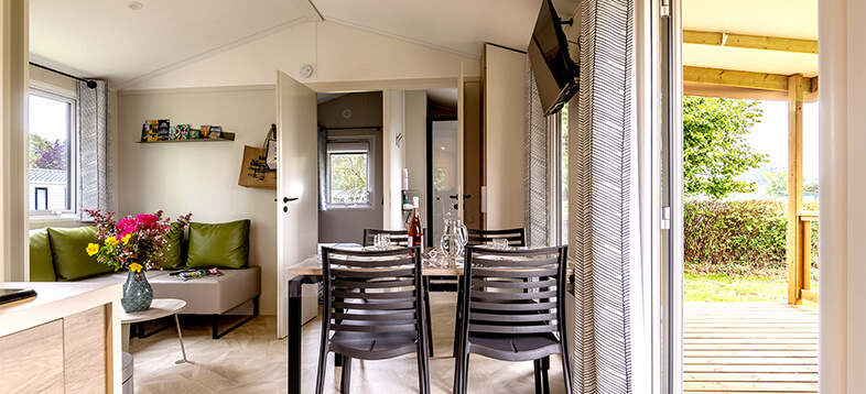La pièce de vie avec cuisine, salon et salle à manger du mobil-home confort 2 chambres, en location au camping La Petite Ville en Bretagne