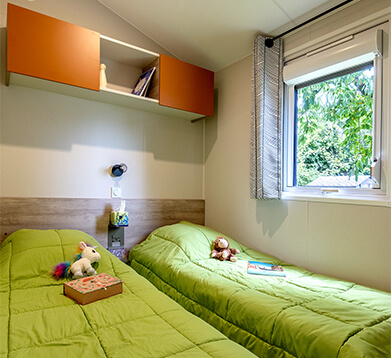 Chambre avec 2 lits 1 personne, du mobil-home confort 2 chambres, en location au camping La Petite Ville en Bretagne