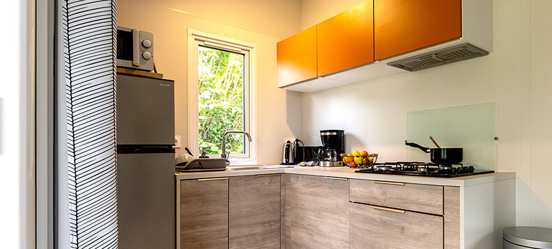 Cuisine équipée avec lave-vaisselle, du mobil-home confort 2 chambres, en location au camping La Petite Ville dans les Côtes d’Armor